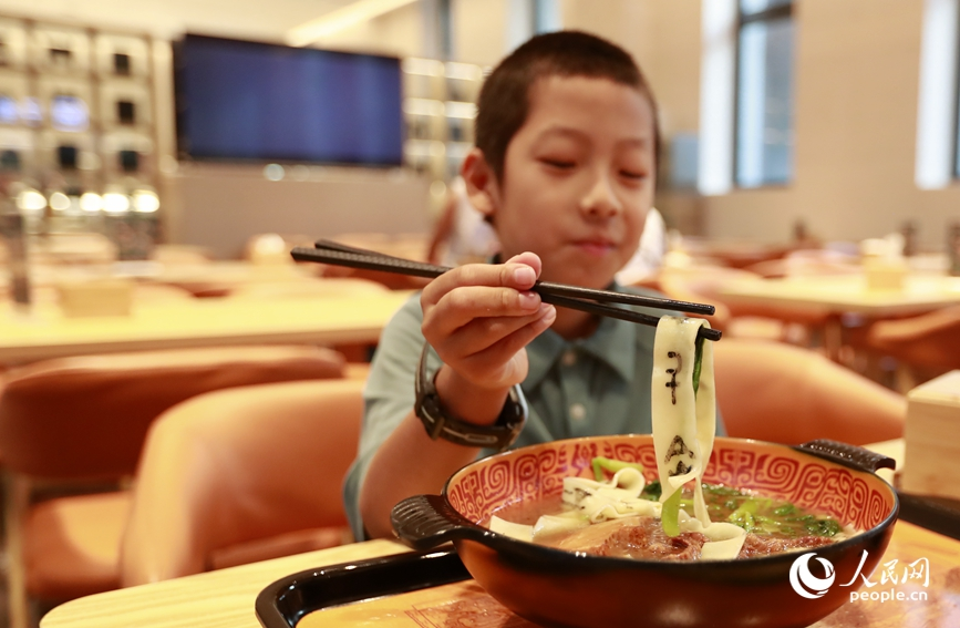 殷墟博物館推出的甲骨文面深受游客喜愛。人民網(wǎng)記者 慎志遠 攝