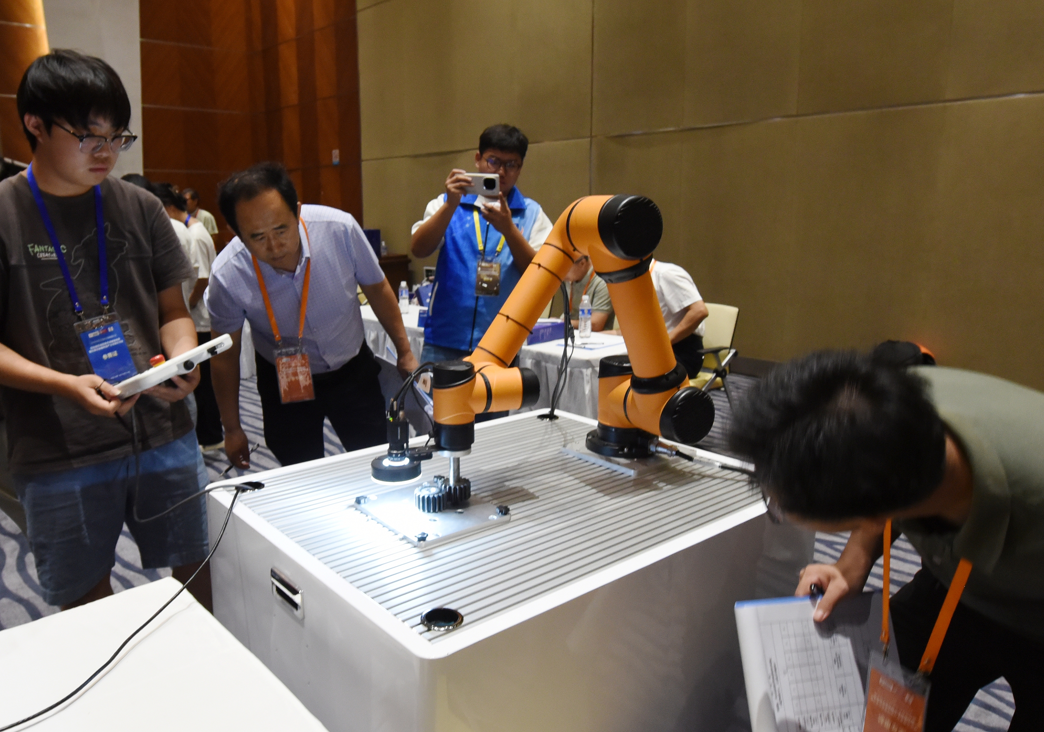 2025年中國大學(xué)生機(jī)械工程創(chuàng)新創(chuàng)意大賽智能精密裝配賽京津冀魯聯(lián)賽現(xiàn)場，評委對參賽選手進(jìn)行實(shí)操調(diào)試評比。
